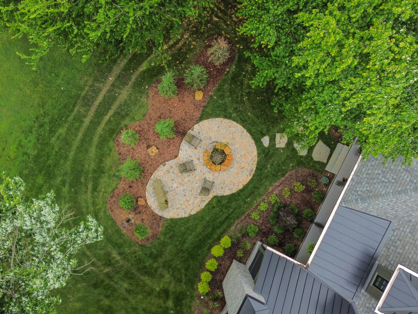 Aerial view of a landscaped backyard with a fire pit and patio area.